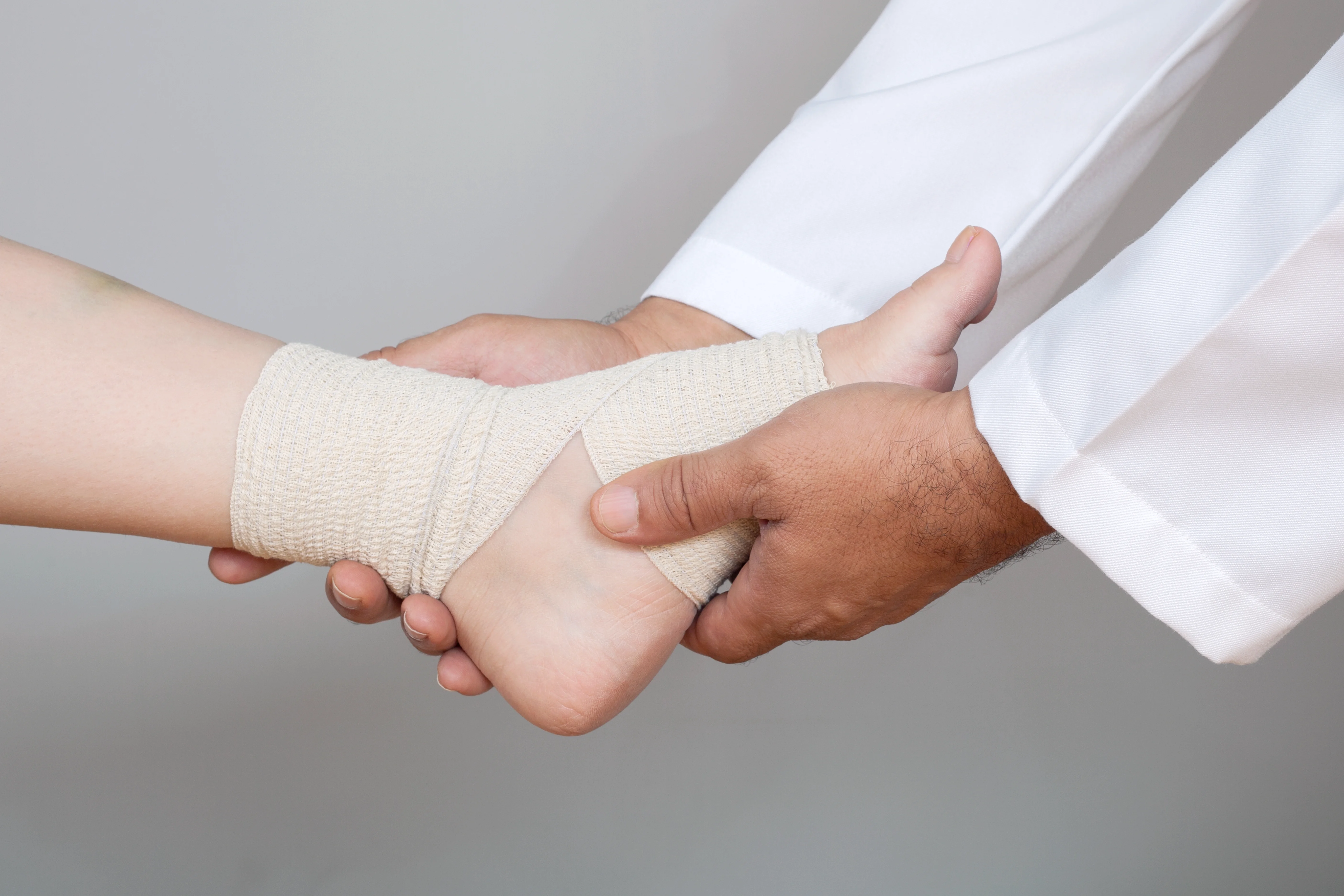 Healthcare provider wrapping a wrist with a supportive bandage – expert injury care.